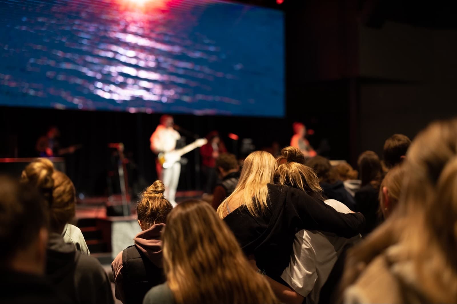Teens embracing during worship at Pleasant Valley Church.